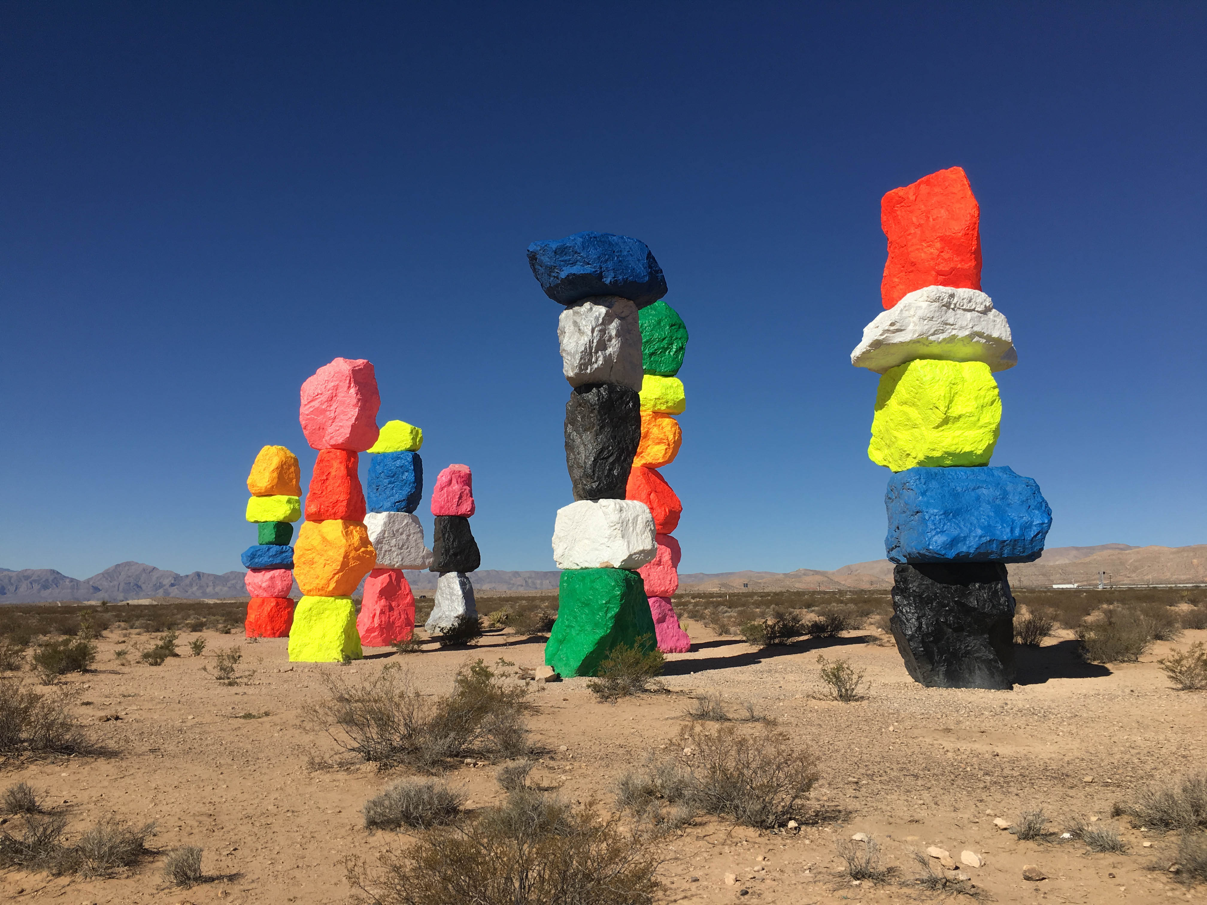 stacked neon rock sculptures in the desert