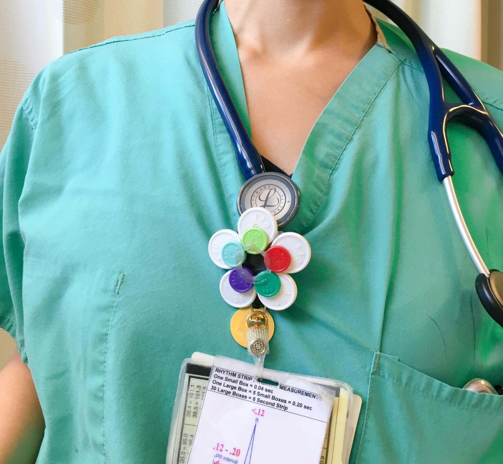 Nurse wearing colorful button made of pillcaps.