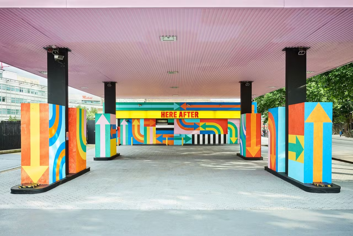 Craig and Karl's Hereafter is a transformed gas station that features large supergraphics of arrows in bright orange, blue, green, yellow, pink, and red. 