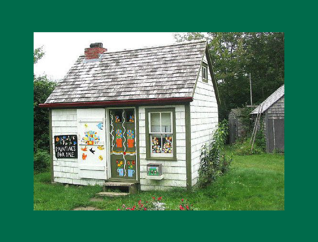 A picture of the artist Maud Lewis's house, featuring colorful paintings on the doors and windows. 