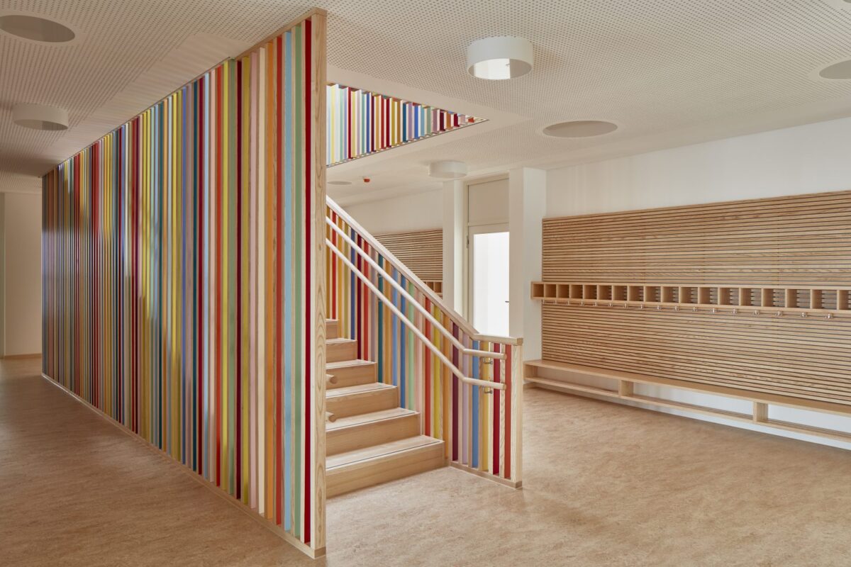 A school staircase with colorful pieces of wood, light passing through. 