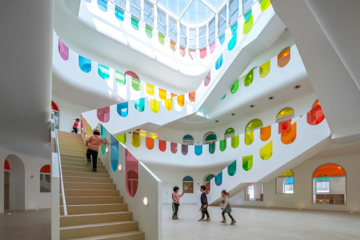 A colorful school building interior, white with colorful panes of glass. 