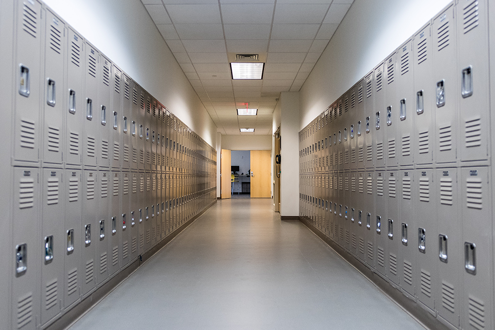A hallway lined with beige lockers on both sides.