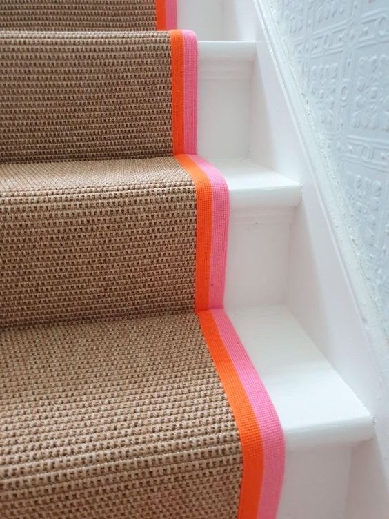 Tan carpet runner with orange and pink colored trim