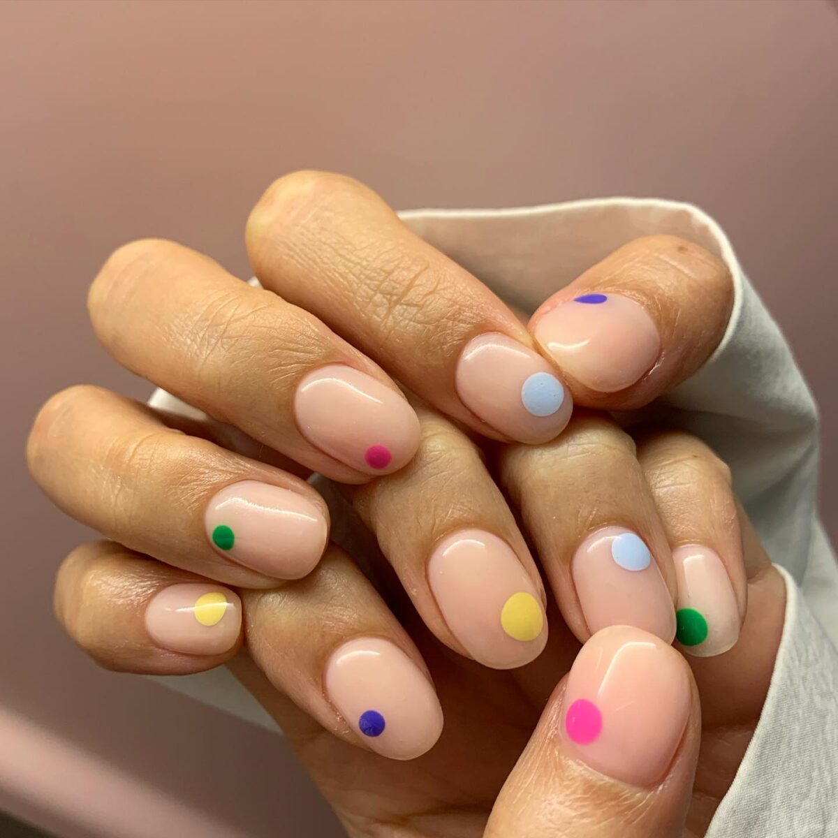 Nude nails with a single colored dot on each nail