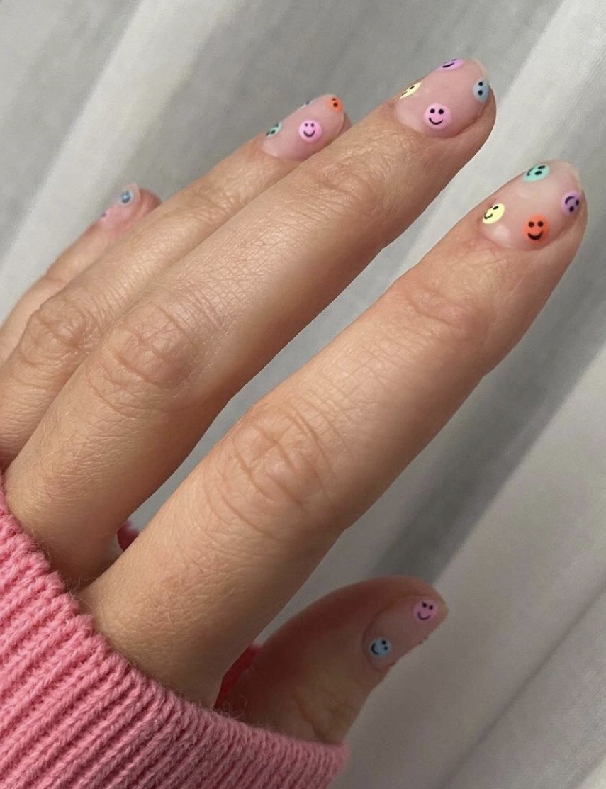 Smiley faces in pastel colors on nude nails