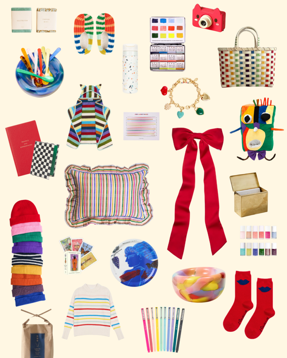 A collage of colorful gift items arranged on a cream background. Items include rainbow-striped knitted slippers, a watercolor palette, a woven multicolor tote bag, a terrazzo water bottle, a red bow, a striped pillow, a stack of colorful beanies, a striped children’s hooded towel, a set of bright markers, multicolored glass bowls and cups, tarot cards, a charm bracelet, nail polishes, a red book and checkered notebook, a plush creature made from colorful fabrics, and various small accessories.