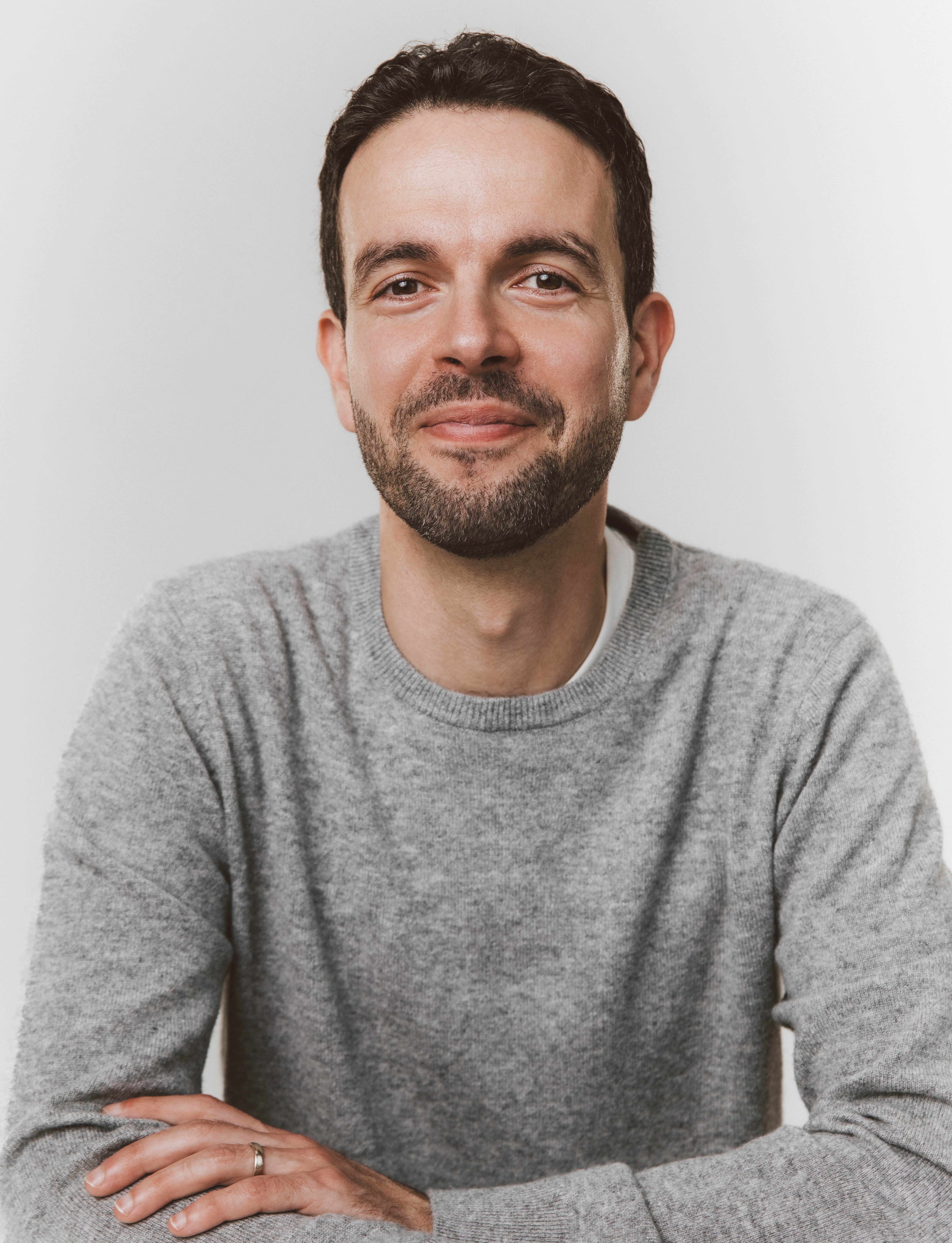 Author Chris Duffy smiles in a grey sweater.